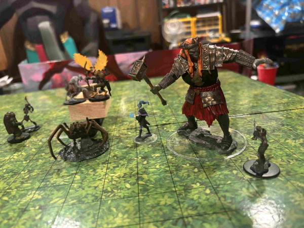 Khari the giant faces off with a skeleton while Marlowe the elf faces the carriage help Varian the katari fight off a wraith, using a ghoul mini. There's also a giant spider mini representing their 8-legged horse.