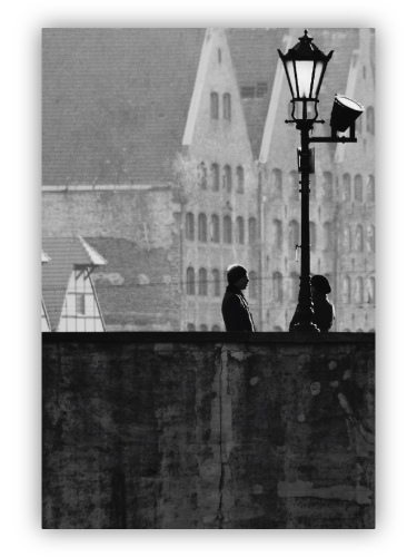 Couple on the bridge under a street lamp.