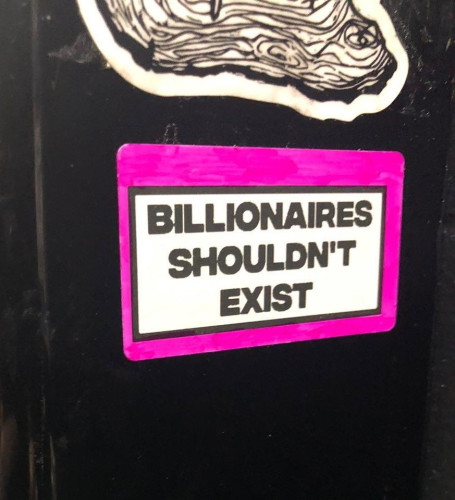 Sticker on a pole that says "Billionaires shouldn't exist"