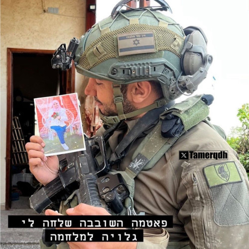 An Israeli soldier shares a picture of himself holding a photograph of a Palestinian woman from a home they raided in Gaza, accompanied by disturbing and inappropriate comments about her.