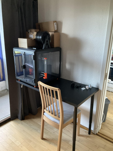 This table shows a worktable with a 3D printer on top and half an empty table - a perfect spot for doing some electronics work. It's just missing tools.