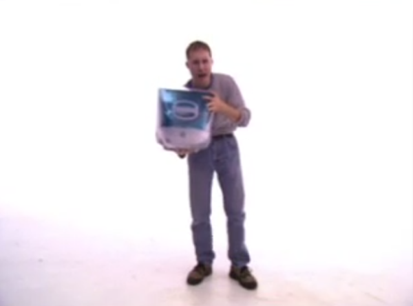 man holding one of those early-2000s Macs with the transluctent CRT casing