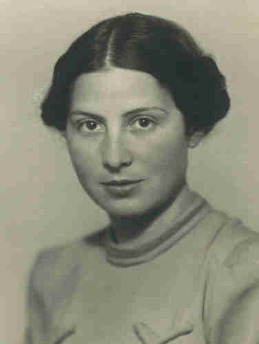 Portrait photo for documents. Young woman in a uniform blouse. She has dark hair reaching her ears - pinned back. Her hair is parted in the middle. She is looking straight into the lens.