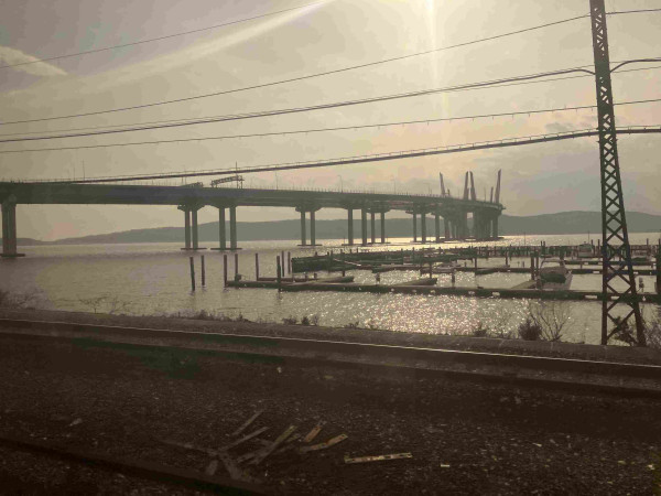 A very large bridge on legs, which some suspension bit in the middle. The sun is low and the photo looks like it was taken with one of the early instagram filters on it, but it’s just that the window is dirty.
