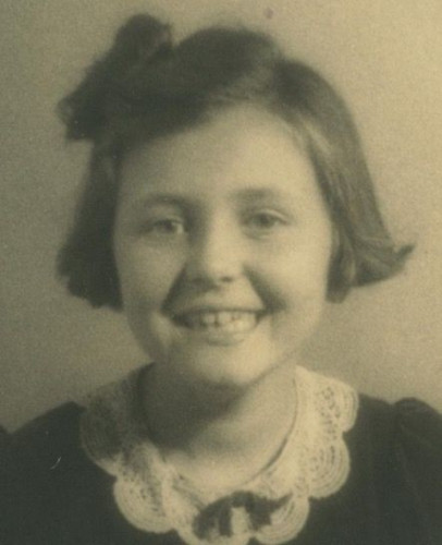 A portrait Id-style photo of a young smiling girl. Her hair cover her ears.