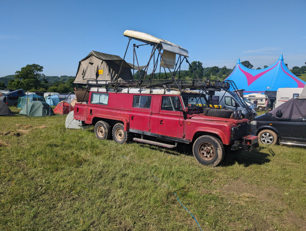 overlong, six wheel red land rover with a roof tent ...