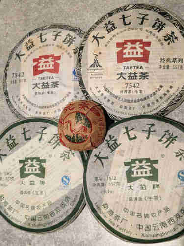 Four Dayi raw puerh cakes and a xiaguan raw puerh tuo.
