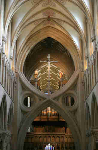 Interior view of the nave of a Gothic cathedral. The centrepiece of the view is an unusual double arch - one arch inverted on top of another, which produces an effect often described as a scissor arch.