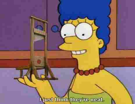 Marge Simpson holding a small model of a guillotine, with the caption "I just think they're neat."