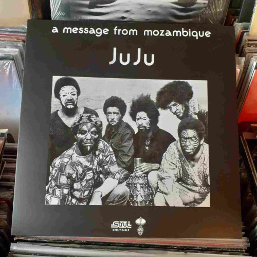 Album cover features a black and white photograph of the musicians, with faces painted in various designs, and wearing dashikis.