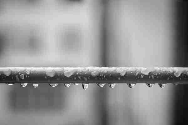 Foto en blanco y negro donde se ve una barra de metal con gotas sobre ella.

B&W photography in which you can see a metal bar with raindrops over It.