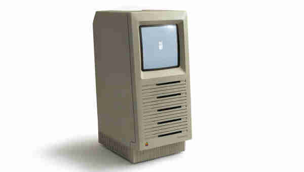 A photo of a very tall Macintosh SE, with five floppy drives. It looks a bit surprised.