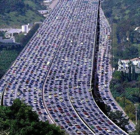 Aerial photo of a sprawling, wide motorway with over 22 lanes, all of them congested and full of cars. 