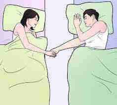 A woman and a man sleep in separat beds while holding hands.