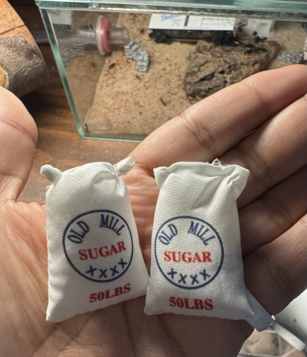 Dollhouse size sacks that say “50 pounds of sugar “