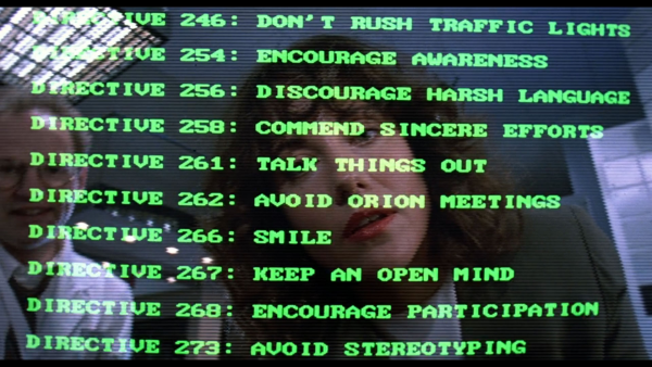 A still image from the 1990 movie "Robocop 2", where a view from the protagonist robot's vision is shown.  The background is an eye-camera image of two engineers checking the settings of the Robocop's software.  Superimposed over the camera image is the text of hundreds of directives, some of them inevitably contradictory, and the plot of the movie is that this huge amount of directives were added to Robocop's operating software in order to provide an improved response compared to Robocop's original 3 directives (a reflection of Asimov's Three Rules).  The superimposed text is in 1990-style monospace uppercase computer font, and is scrolling in the movie, but in this still image it says the following:

DIRECTIVE 246: Don't rush traffic lights.
DIRECTIVE 247: Don't run through puddles and splash pedestrians or other cars.
DIRECTIVE 248: Don't say that you are always prompt when you are not.
DIRECTIVE 249: Don't be oversensitive to the hostility and negativity of others.
DIRECTIVE 250: Don't walk across a ballroom floor swinging your arms.
DIRECTIVE 254: Encourage awareness.
DIRECTIVE 256: Discourage harsh language.
DIRECTIVE 258: Commend sincere efforts.
DIRECTIVE 261: Talk things out.
DIRECTIVE 262: Avoid Orion meetings.
DIRECTIVE 266: Smile.
DIRECTIVE 267: Keep an open mind.
DIRECTIVE 268: Encourage participation.
DIRECTIVE 273: Avoid stereotyping.