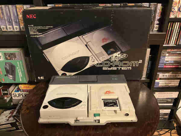 A CD-Rom^2 with a PCEngine sitting in an IFU-30 in front of its original packaging.