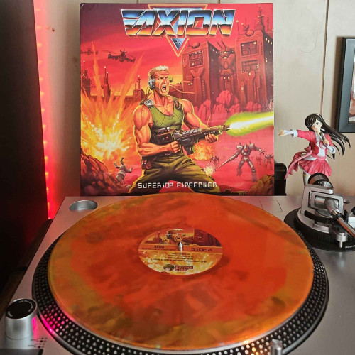 A trans orange & yellow swishy wishy vinyl with sliver splatter sprinkles & silver texture splatter stripes vinyl record sits on a turntable. Behind the turntable, a vinyl album outer sleeve is displayed. The front cover shows art of a soldier firing a futuristic gun and screaming, while alien robots are in the background. The setting is on a red planet with alien like structures in the background. 