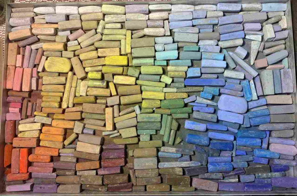 A huge box of pastel sticks arranged in spectrum.