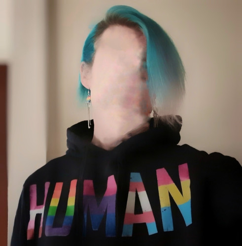 Me with my face blurred out, teal hair showing, Pride rainbow lockpick earrings, and a black hoodie that says "HUMAN" in big block letters. Each letter is a different LGBTQ flag.