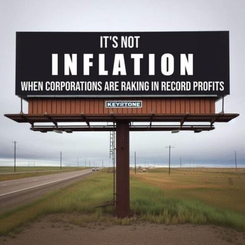 Billboard in the median in an empty road reads, "It's not inflation when corporations are raking in record profits"