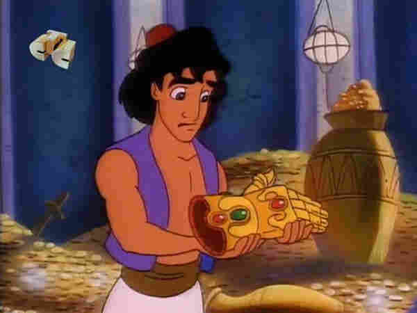 Aladdin holding a golden gauntlet with red and green gemstones inlaid 