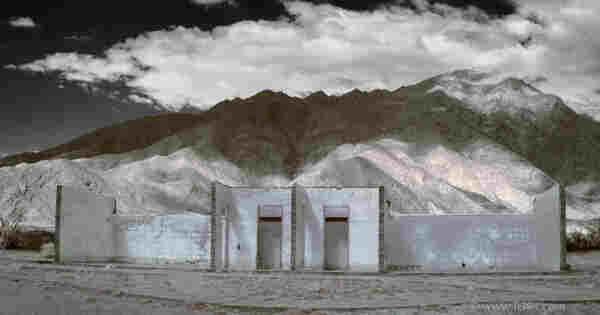 empty ruins of hotel by mountain, in desert