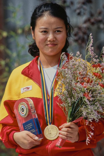 Zhang Shan holding a bouquet of flours and wearing her Olympic gold medal

