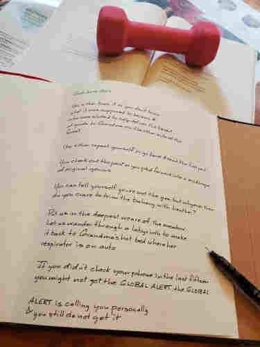 Handwritten transcription under way of the poem "Such Love Alert" from That Audible Slippage by Margaret Christakos - the book is held open with a small, pink hand weight, and an uncapped black pen rests on the notebook page