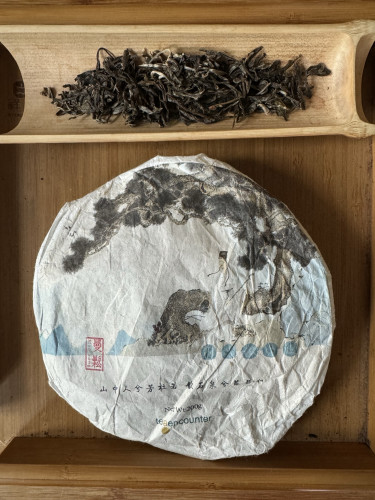 Puerh tea cake in wrapper and dry tea leaves 