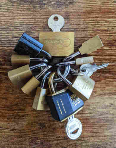 9 tiny locks locked to the shackle of a slightly larger tiny lock.