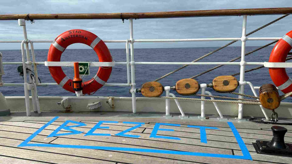 Aft deck of a ship with the word BEZET spelled in blue painters tape