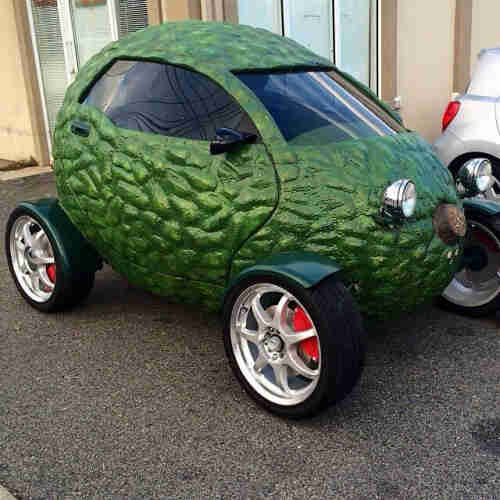 a small vehicle in the shape of an Avocado. four wheels. Like a dune buggy frame.