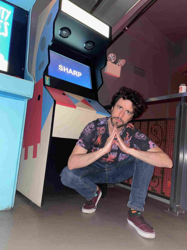 me doing a rap squat in front of the Super Sharp Birds arcade machine