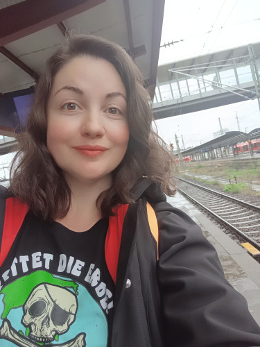 Selfie von Anja am Bahngleis. Sie trägt ein Shirt mit einer Comicerde und einem Piratenschädel. Es steht darauf: Rettet die Erde, sie ist der einzige Planet mit Piraten 
