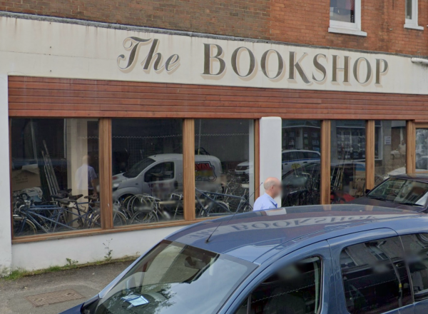 A shop. The sign says The Bookshop. The inside is full of bikes