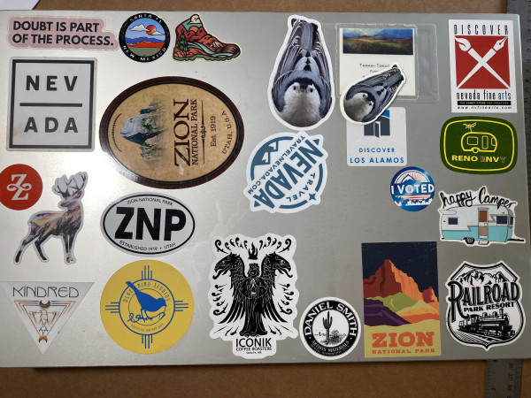 A large aluminum box with lots of stickers; national parks, Nevada-themed, small shops, and Loren's cute nuthatch. 