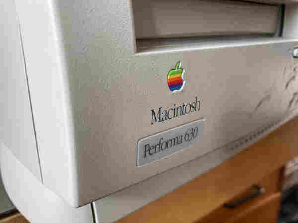Closeup of a beige Macintosh Performa 630 with the rainbow Apple logo and the CD ROM drive shown.