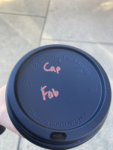 The lid of a a takeaway coffee cup with Fab written as the order name 