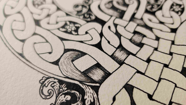 Filling in detail on the rope of a celtic knot with super fine black ink lines so they look like hair