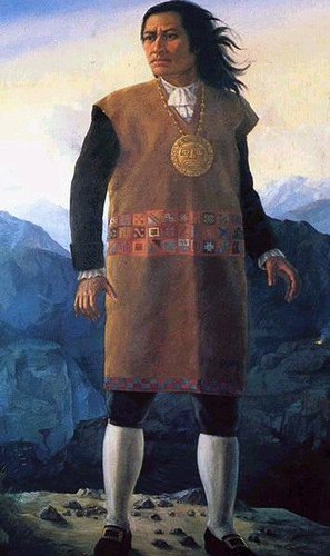 Tupac Amaru II standing tall, in a brown tunic, with white knee socks, and a golden medallion around his neck. By Unknown author - http://peru.feeder.ww7.pe/index.php?cal_date=2009-07-29, Public Domain, https://commons.wikimedia.org/w/index.php?curid=9105047