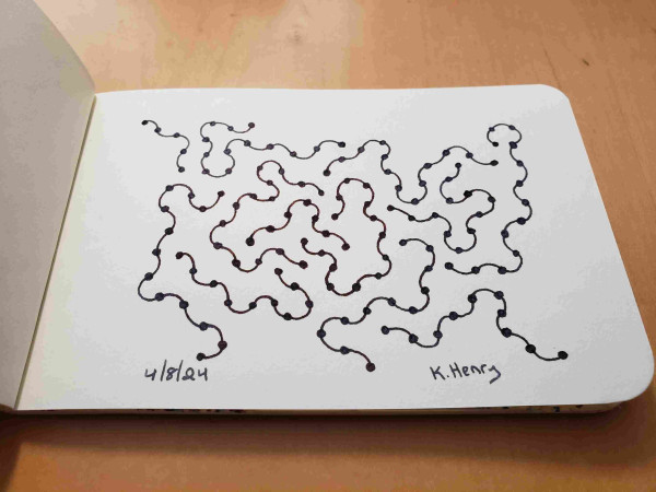 Hand drawn generative art in ink on an open page of my sketchbook. The abstract pattern is difficult to describe, but kinda looks like a cross section of ribosomes on the er in a cell.