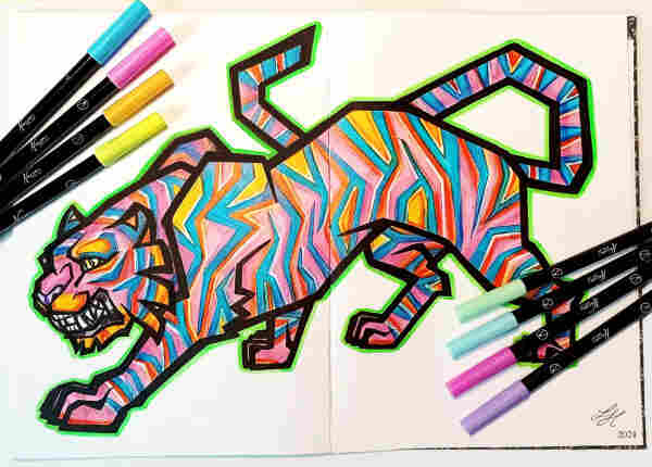 a photo of a huge open sketchbook, showing a stylized tiger prowling across two pages, with some markers arranged at the edges