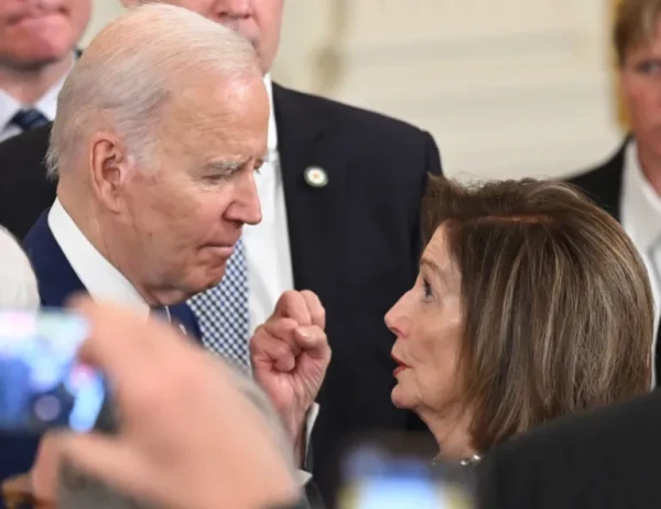 US President Joe Biden talks with US Representative Nancy Pelosi, a Democrat of California, after speaking at a White House event in March [File: Saul Loeb/AFP]