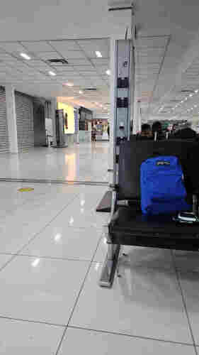 foto del área superior de espera, Aeropuerto Internacional Benito Juárez, CDMX, México

se ve un pasillo de losetas beige a la izquierda y un asiento negro con una mochila azul al lado derecho