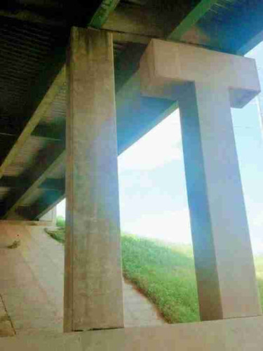 A picture from ground level looking up of a concrete bridge. Two supports are visible in the shape of the letter 'I' and the letter 'T'