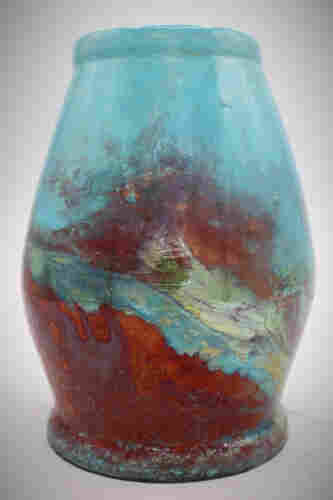A raku pottery vase in a light blue with reds and metallics.