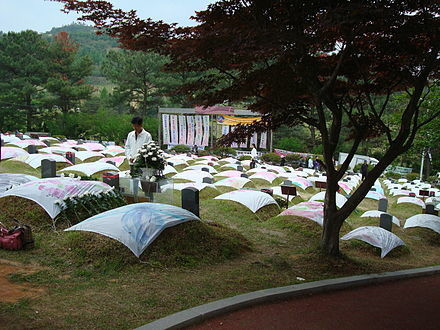 The victims of the Gwangju Massacre were buried at the May 18th National Cemetery. This image shows burial mounds, each draped with a colored sheet. By Rhythm - Own work, CC BY-SA 3.0, https://commons.wikimedia.org/w/index.php?curid=4089746