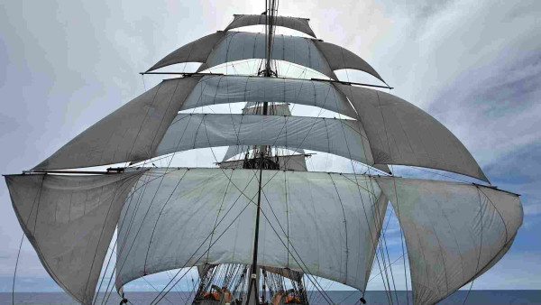 Square rigged ship with three auxiliary sails on each side of the foremast. 