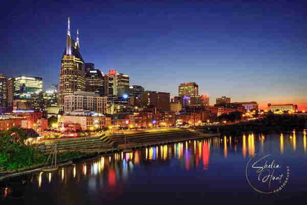 Beautiful evening cityscape of Nashville, Tennessee with colored lights reflecting in the Cumberland River. Nashville is the Country Music capital of the World. Stunning artwork for those who love Nashville and those who love country music. Artwork from Fine Art Gallery of Shelia Hunt.